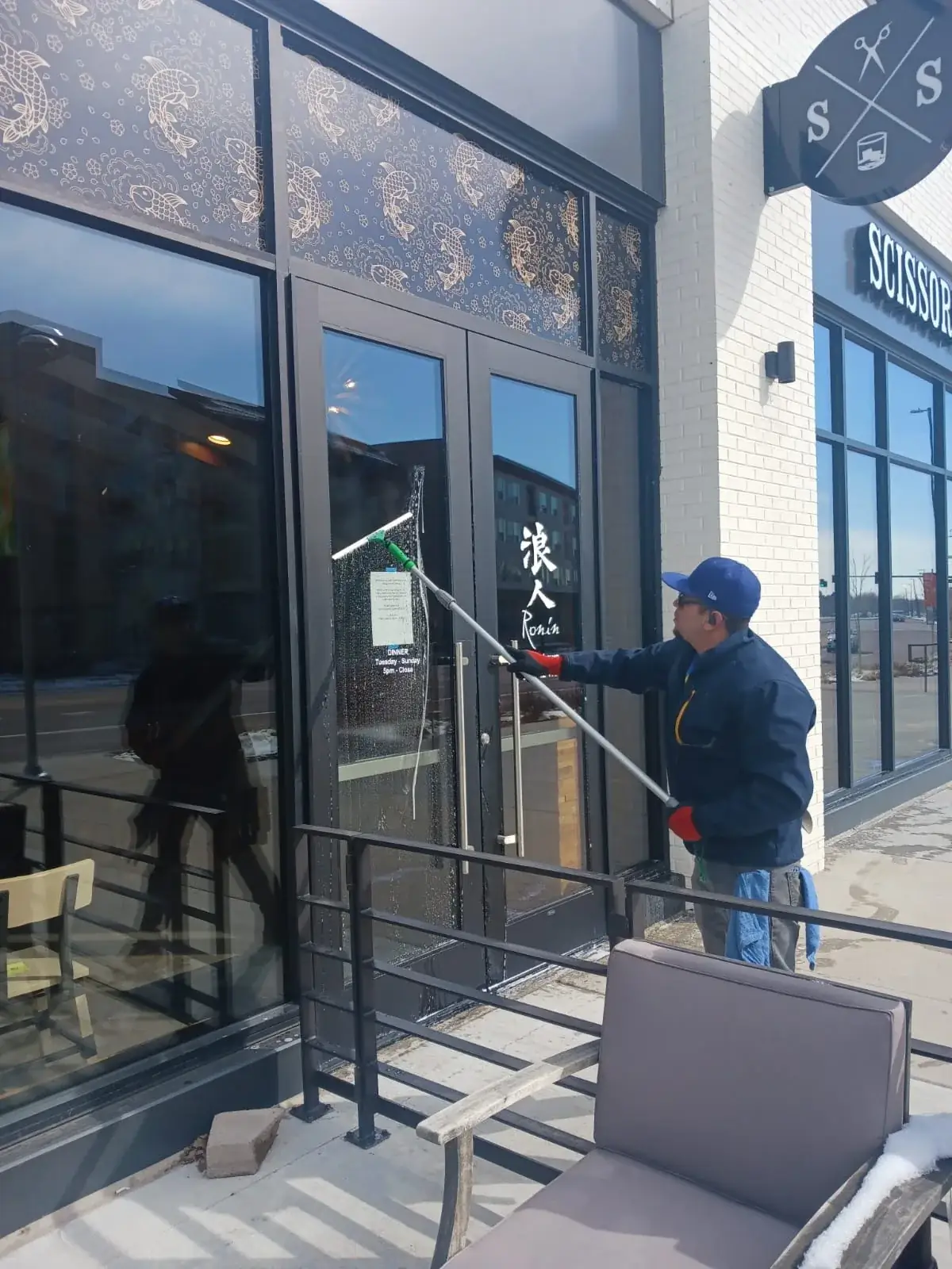 Joe's technician cleaning the double glass doors of a restaurant