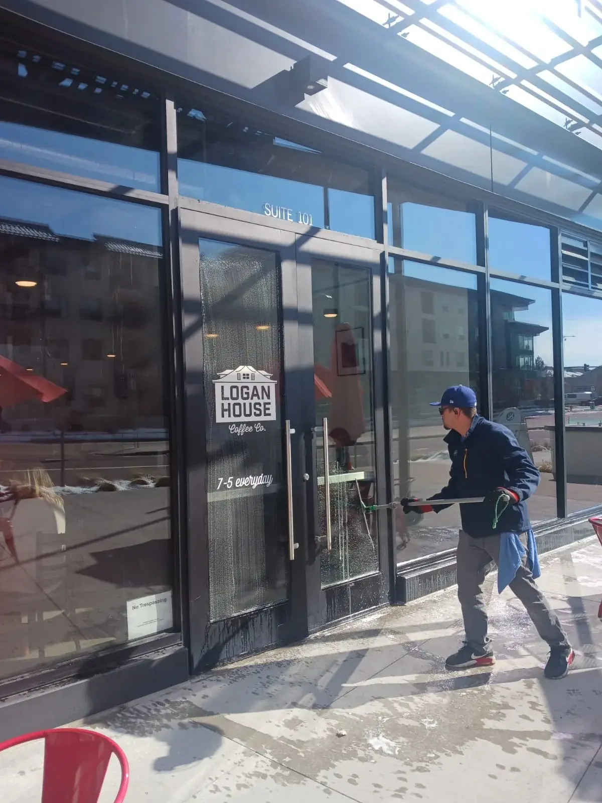 Joe's technician squeegeeing the glass doors of a coffee shop