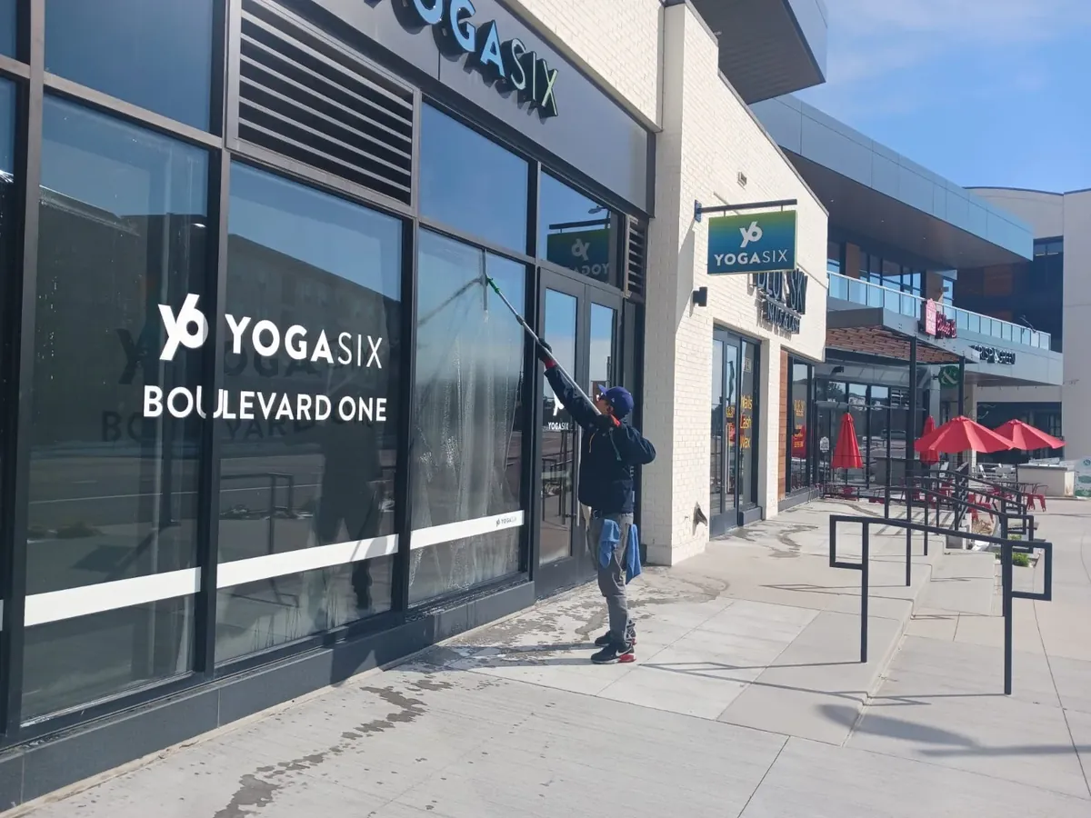 Joe's technician cleaning storefront windows in a shopping center