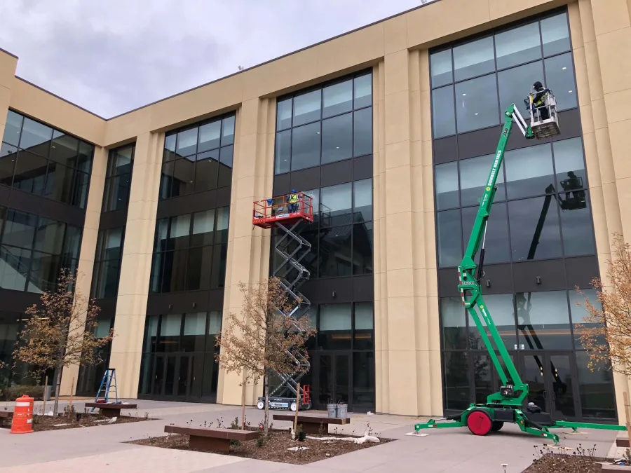 Joe's technicians using boom and scissor lifts to clean a commercial building's windows