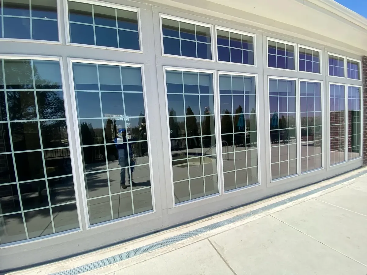 Joe's technician's reflection in freshly cleaned exterior windows overlooking a pool and patio