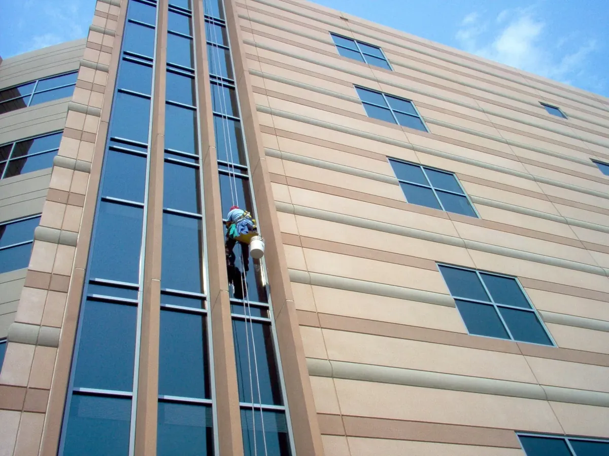 Joe's technician on rope access cleaning the windows of a multi-story building