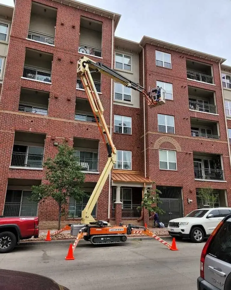 Sample: Joe's crew using a boom lift to clean the windows of a brick apartment building