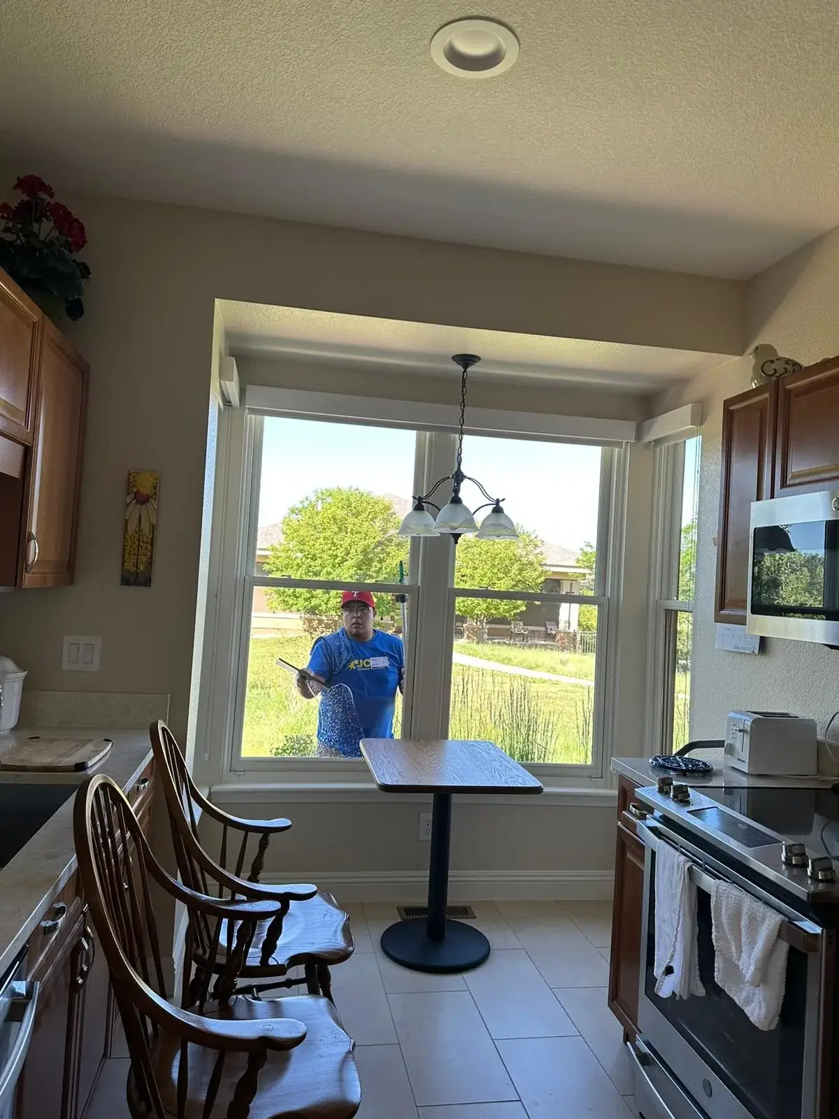 Joe's technician cleaning a bay window in a home kitchen