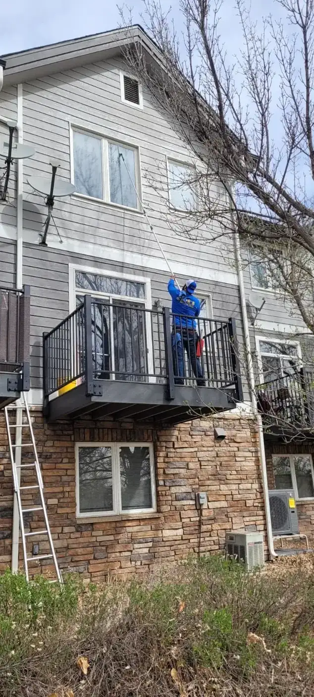 Joe's technician cleaning windows on a townhome balcony