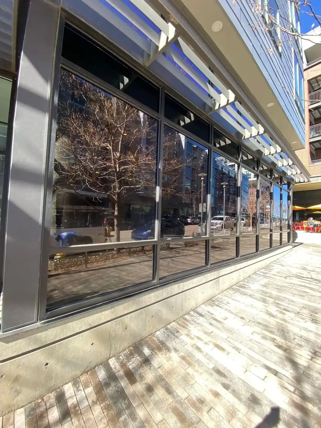 Sample of freshly cleaned storefront glass reflecting an urban plaza