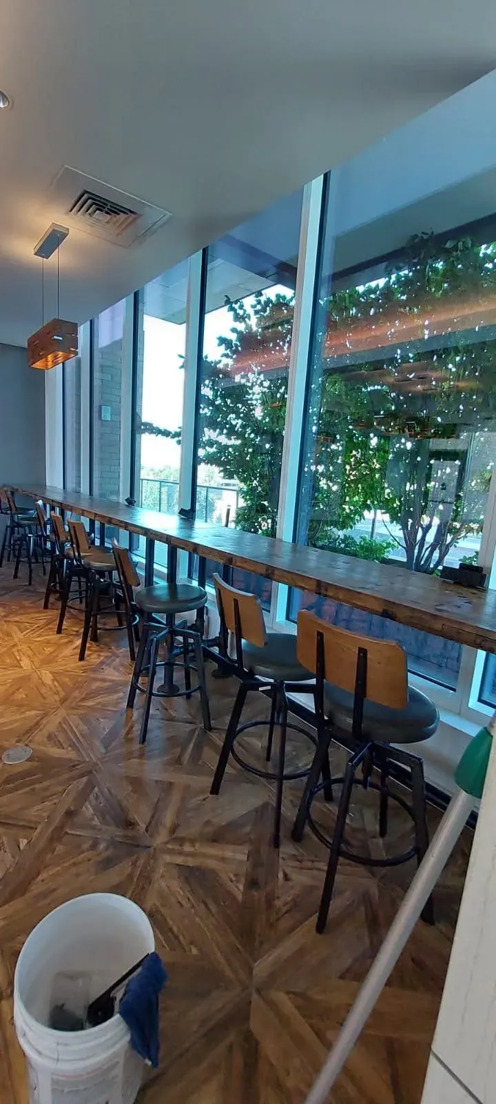Joe's Window Cleaning technician cleaning windows at a restaurant interior