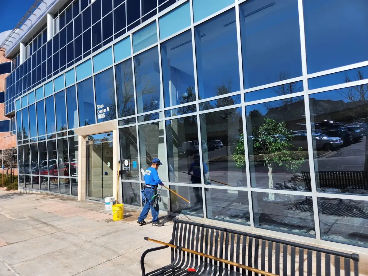 Joe's Window Cleaning technicians using extension poles to clean the glass exterior of an office building